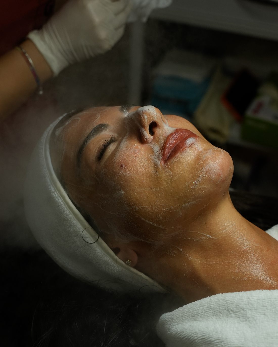 A facial treatment with steam, the client resting in a headband